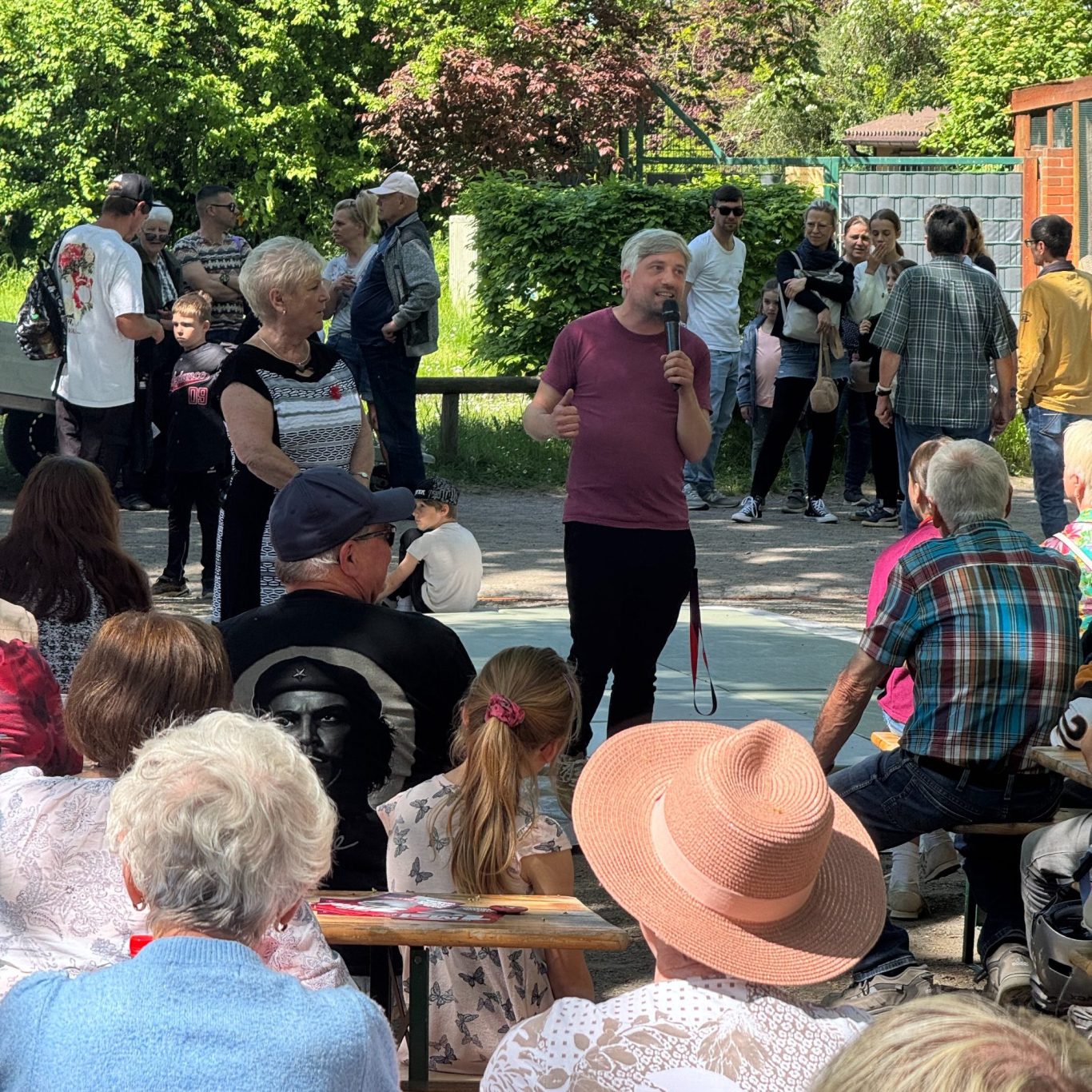 Rede 1. Mai in Oschersleben David Schliesing spricht zu Menschen in einem Biergarten
